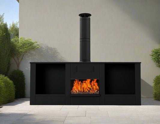 A black stainless steel big outdoor fireplace with a visible firebox and a chimney, set in an outdoor setting with plants in the background.