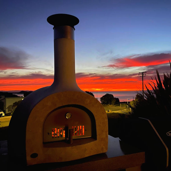 Wood-fired pizza oven with a sunset