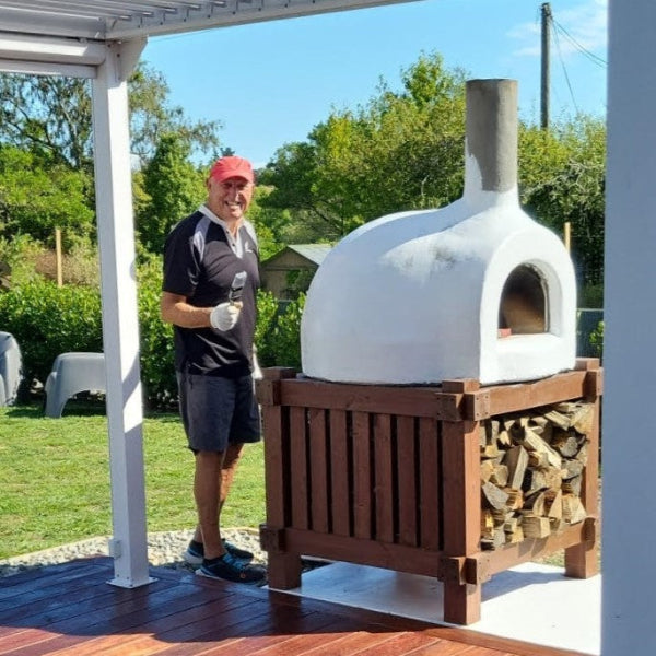 Man painting  a wood-fired pizza oven