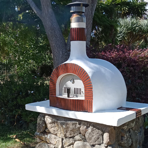 White outdoor pizza oven with brick design on a stone base