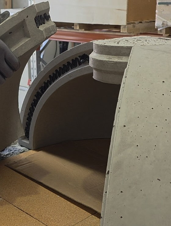 Refractory dome section being fitted during assembly of a wood-fired pizza oven.