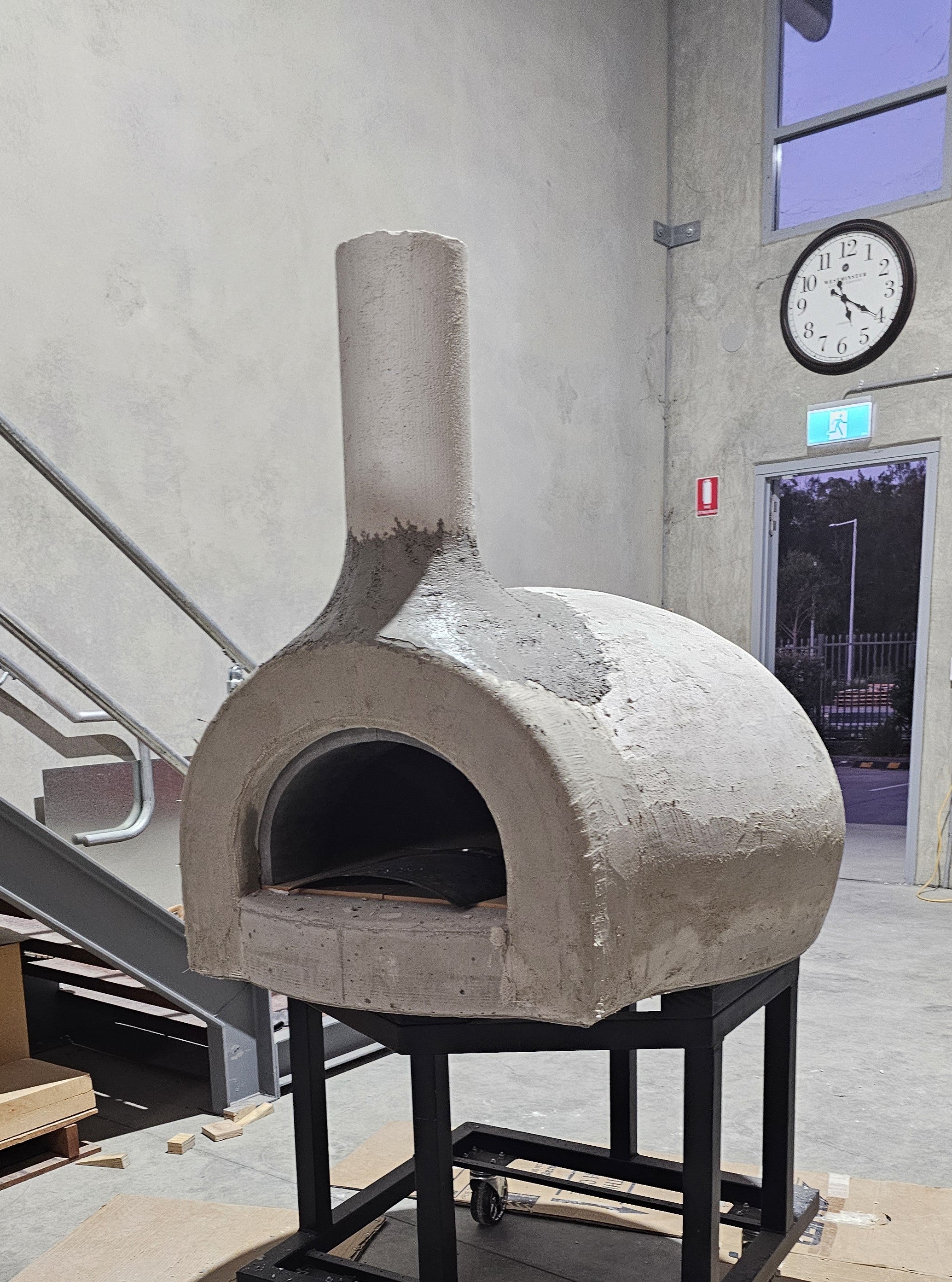 Wood-fired pizza oven during assembly with the entrance and chimney fitted before final finishing.